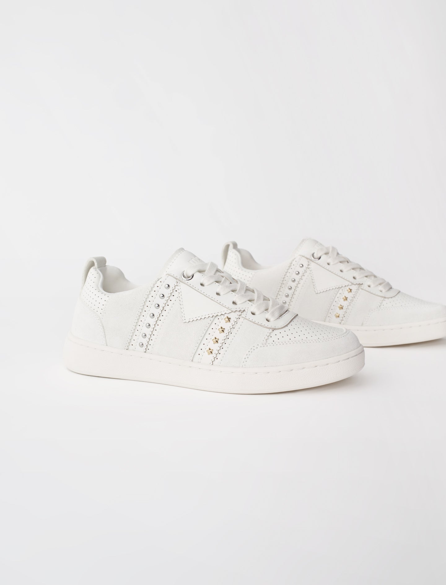 Sneakers de piel blancos con tachuelas
