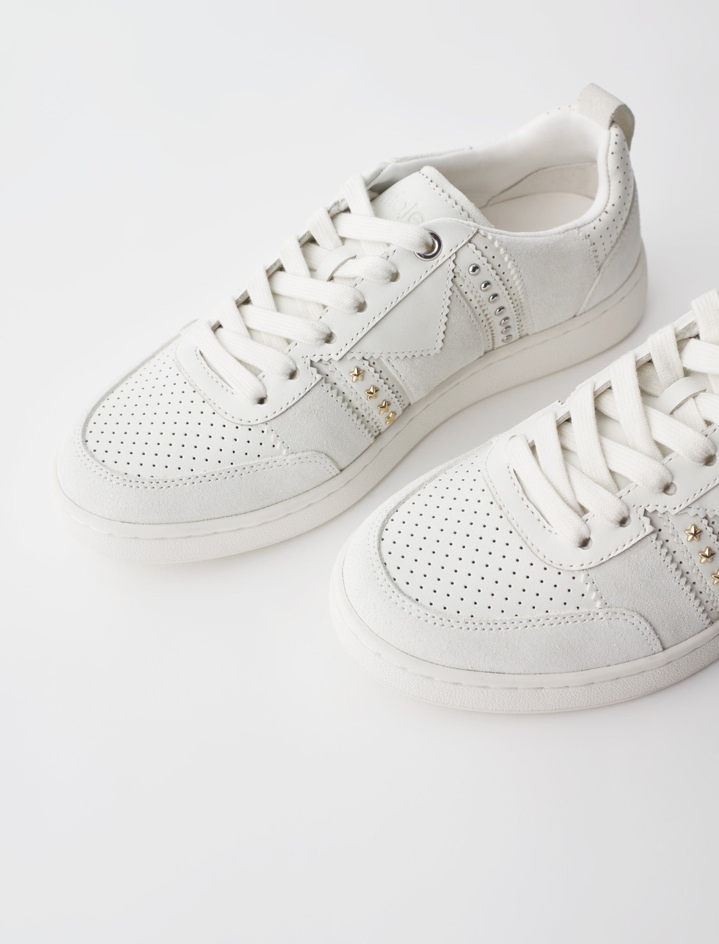 Sneakers de piel blancos con tachuelas