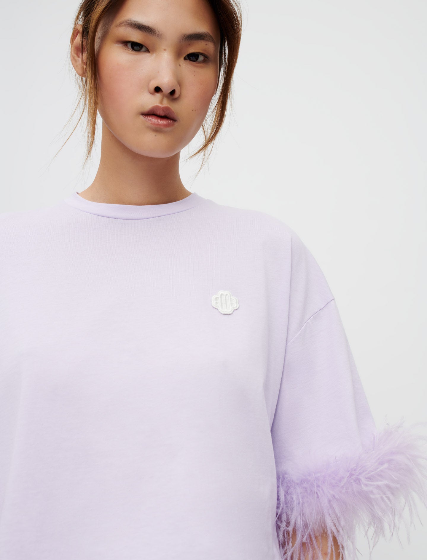 Camiseta lila con plumas