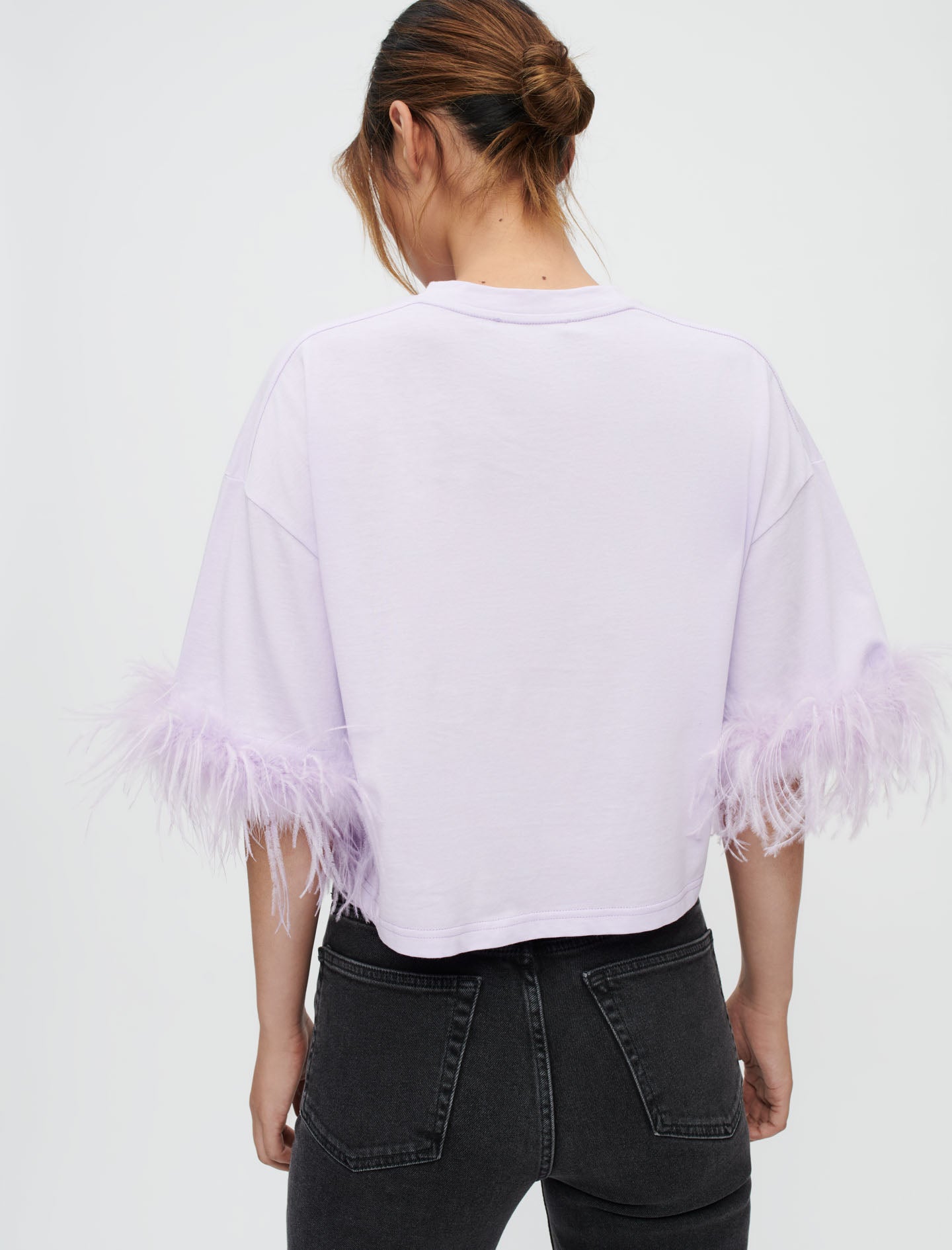 Camiseta lila con plumas